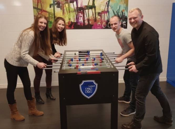 Gruppe spielt Kicker.