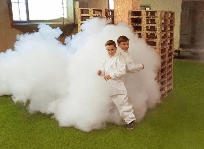 Kindergeburtstag spielt Nerf, zwei Spieler stehen in einer großen Nebelwolke.
