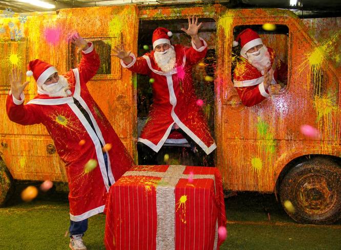 Drei Weihnachtsmänner posieren auf dem Spielfeld.