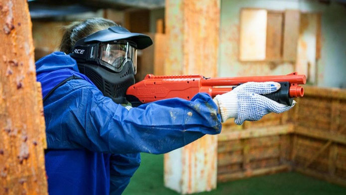 Player holds a paintball marker.